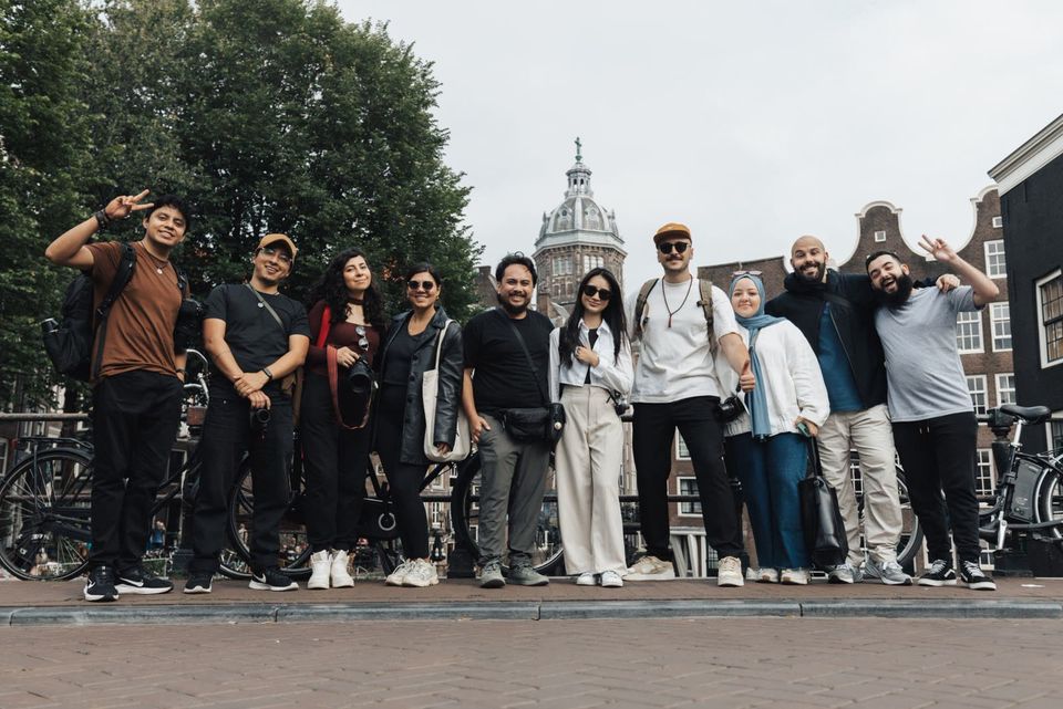 Rombongan traveler muda berfoto bersama di sebuah jalan kota